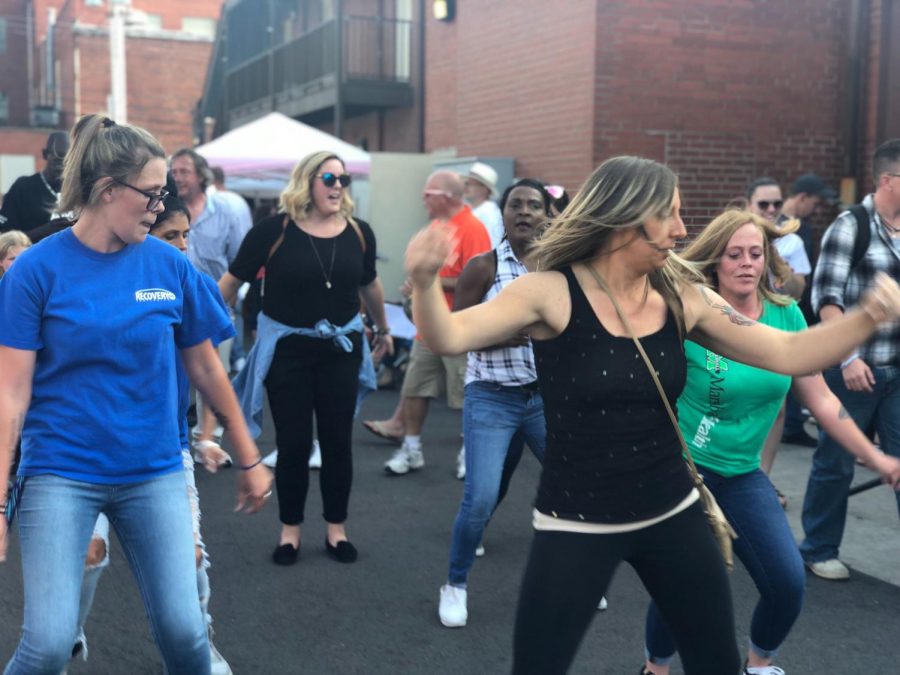 Local community members dance as part of celebrations Friday at Recovery Point’s eighth annual Rally for Recovery in Huntington.