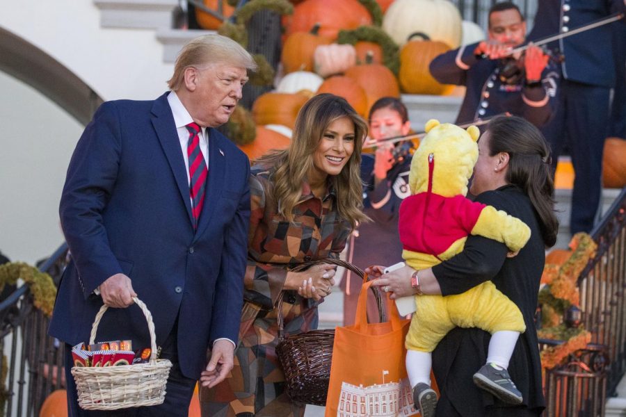 President Donald Trump and First Lady Melania Trump give candy to children during a Halloween trick-or-treat event on the South Lawn of the White House which is decorated for Halloween, Monday, Oct. 28, 2019, in Washington. 