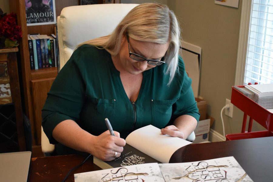 Marshall criminal justice alum Casey Bond signs a copy of her new book, “When Wishes Bleed.” The book will be released and available to readers Friday, Nov. 1.