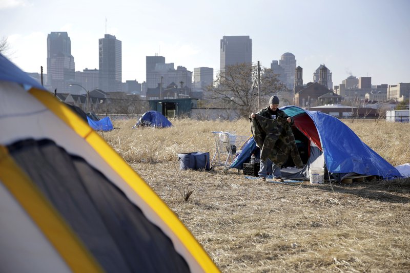 In this Tuesday, Jan. 27, 2015 file photo, Terry cleans out his tent at a large homeless encampment, near downtown St. Louis.