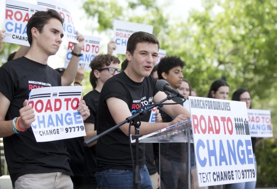 In this June 4, 2018 photo, Cameron Kasky, center, speaks during a news confrence in Parkland, Fla., announcing a multistate bus tour to get young people educated, registered and motivated to vote.
