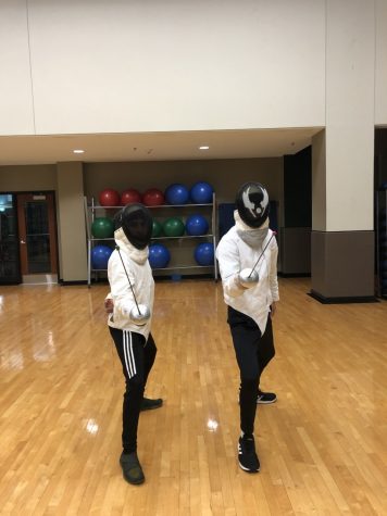 Marshall University Fencing Club members Elijah Vela and Scott Cooper show off fencing gear and pose.