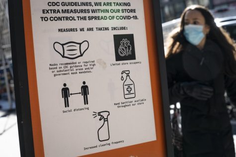 Pedestrians wearing protective masks walk along Broadway in the SoHo district of New York, Friday, March 4, 2022. Mayor Eric Adams announced in a morning news conference that the city will be scaling back of COVID-19 mask and vaccine mandates.