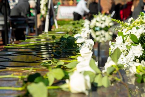 Roses lay on the base of the memorial fountain during the ceremony. 