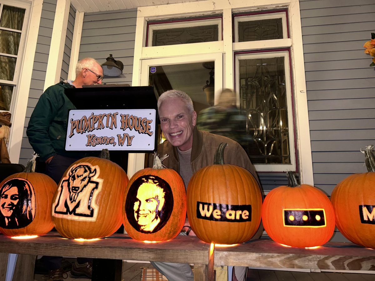 University President Brad D. Smith poses in front of a pumpkin designed in his likeness.