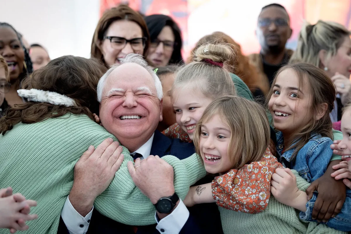 Minnesota Gov. Tim Walz gets a hug from students after he signed into law a bill that guarantees free school meals for students in Minnesota’s public schools.