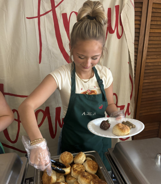 Alpha Xi Delta member Mychal Cron serves breakfast at the 2024 Strawberry Breakfast.