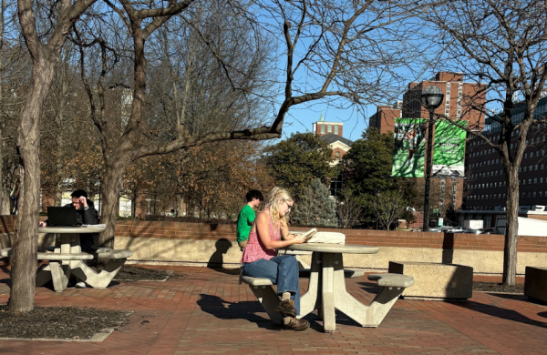 Students utilize study spots outside the student center on a warm weekday. 